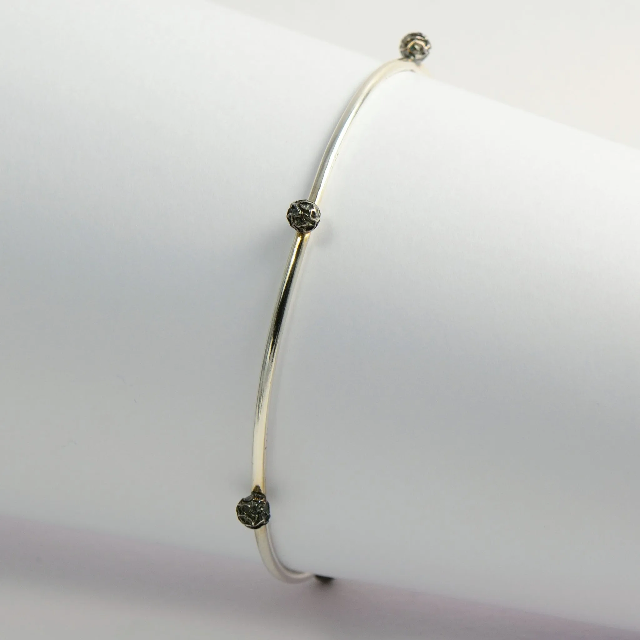 A Set of three bangles, with stellar peppercorns design accented with gold vermiel, dark and bright silver sterling